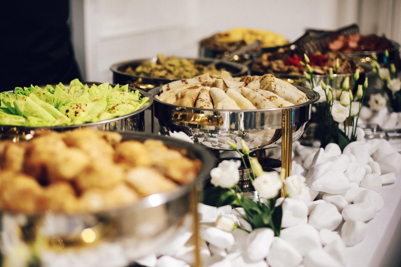 Catering buffet with chafing dishes of wraps, salads and hot food